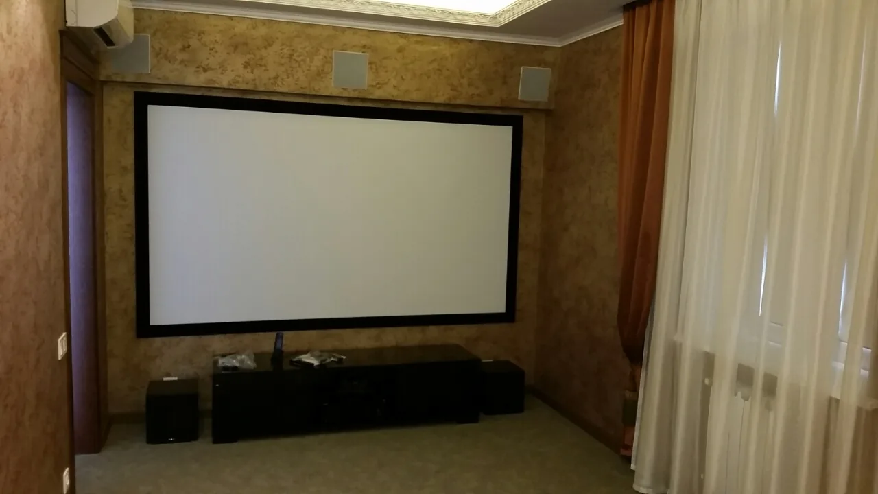 Интерьер гостиной с экраном домашнего кинотеатра после ремонта